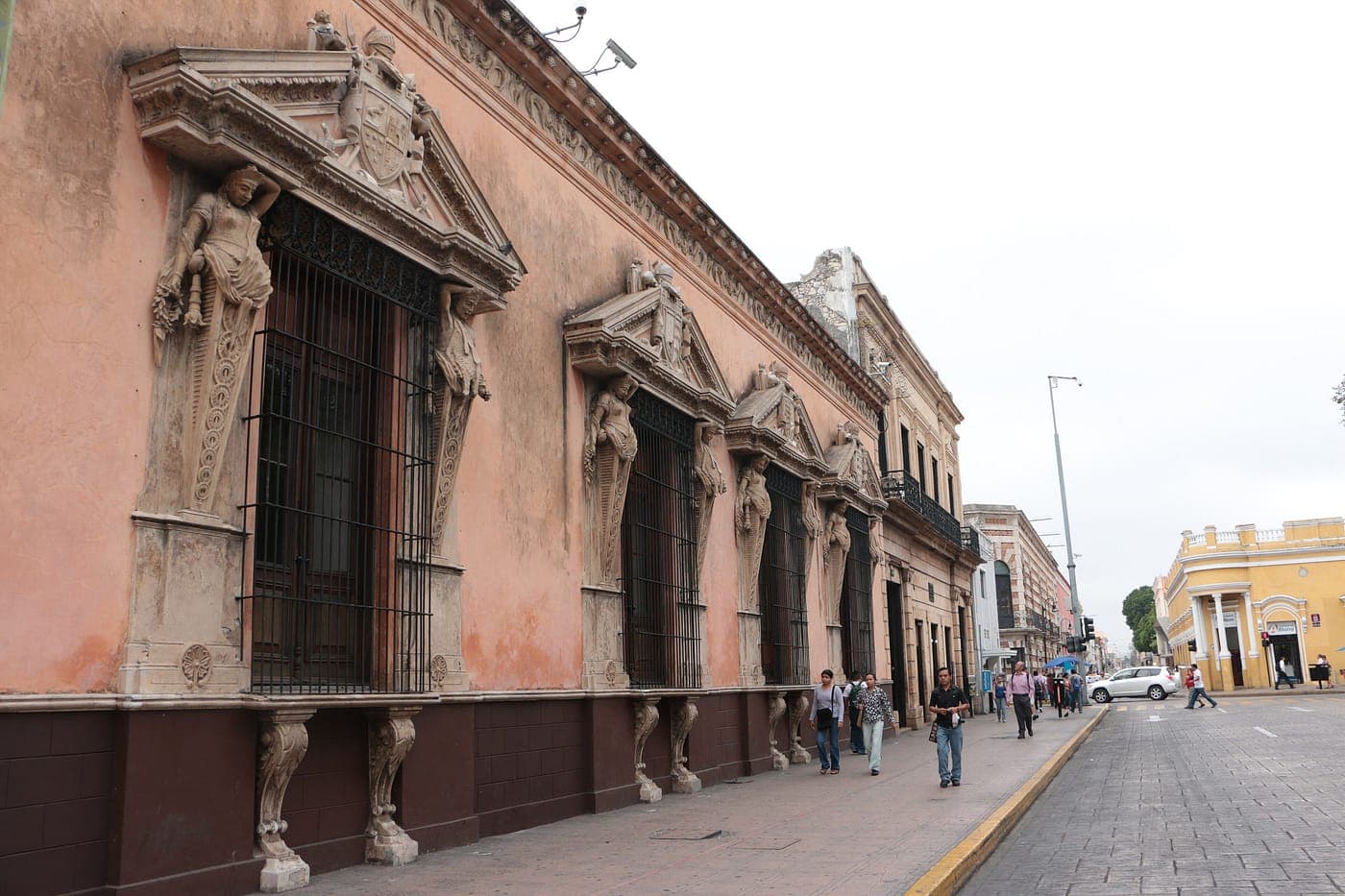 La fachada plateresca de la Casa de Montejo, en piedra rosada, con sus figuras talladas sobre la puerta.