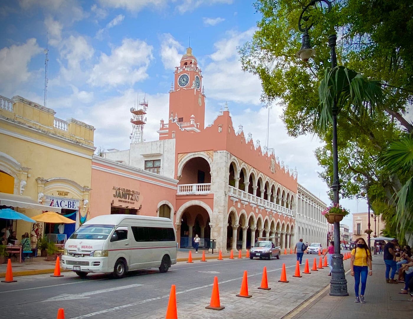 Fachada blanca y roja del Palacio Municipal de Mérida, con su torre del reloj y los arcos de la planta baja.
