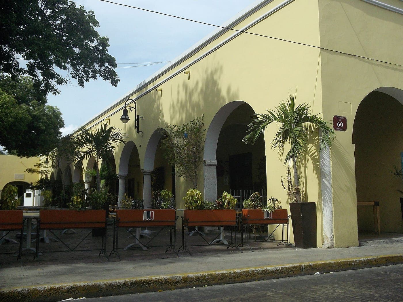 Los portales del Parque de Santa Lucía: una hilera de arcos amarillos con macetas y bancas debajo.