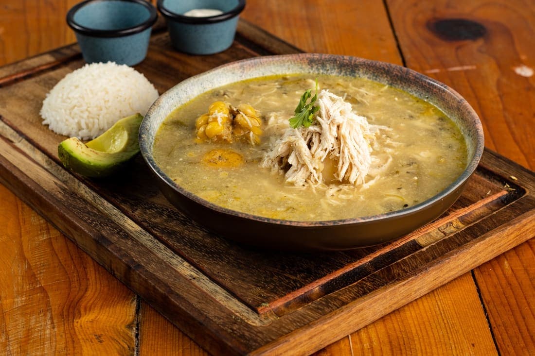 Ajiaco santafereño: Sopa cremosa preparada con pollo, papas colombianas y el aroma único de las guascas.
