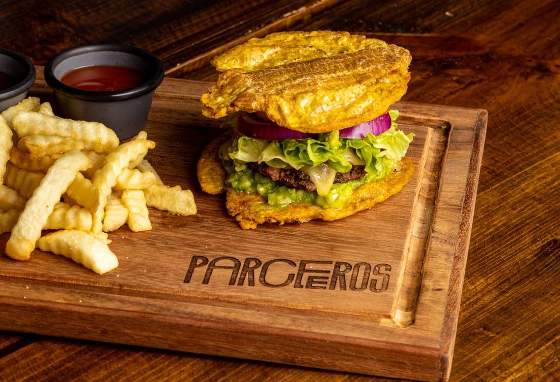Pataburger: Carne a la parrilla, queso fundido y salsas cremosas entre dos patacones crujientes. Con papas a la francesa.