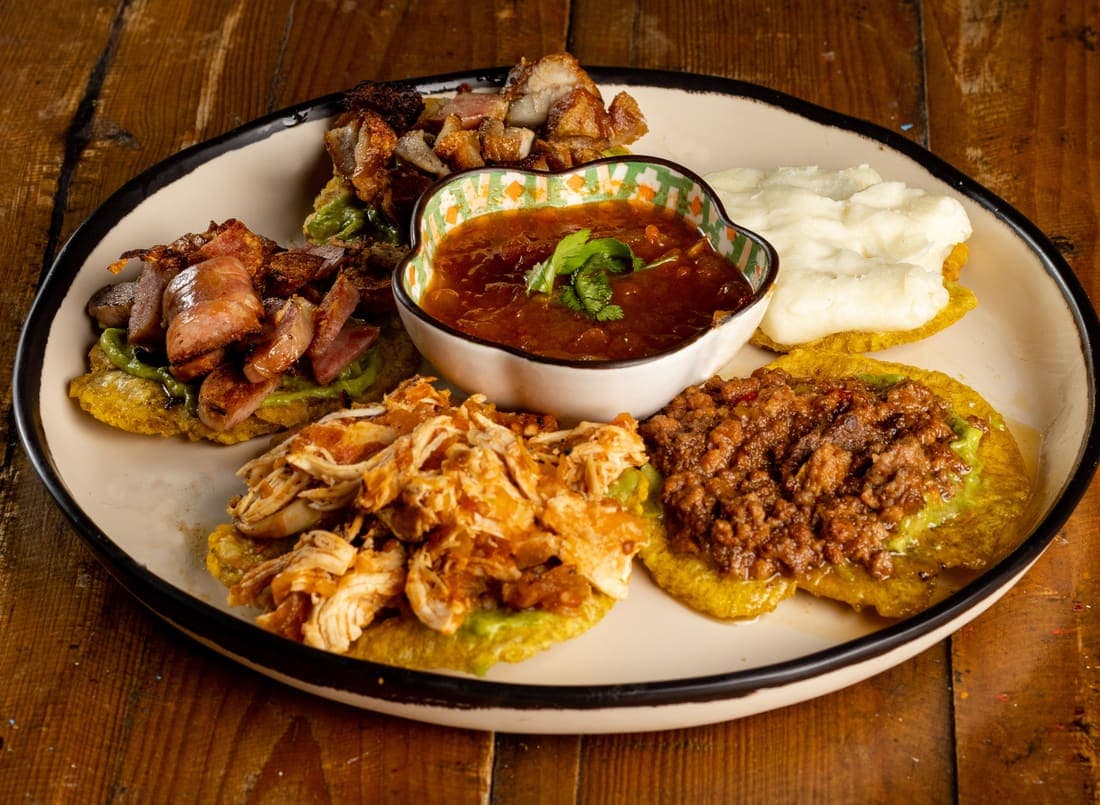 Patacones Recocheros: Andan revueltos, por eso llevan de todo y en más cantidad: guacamole, pollo, carne molida, chicharrón, chorizo y queso fundido.
