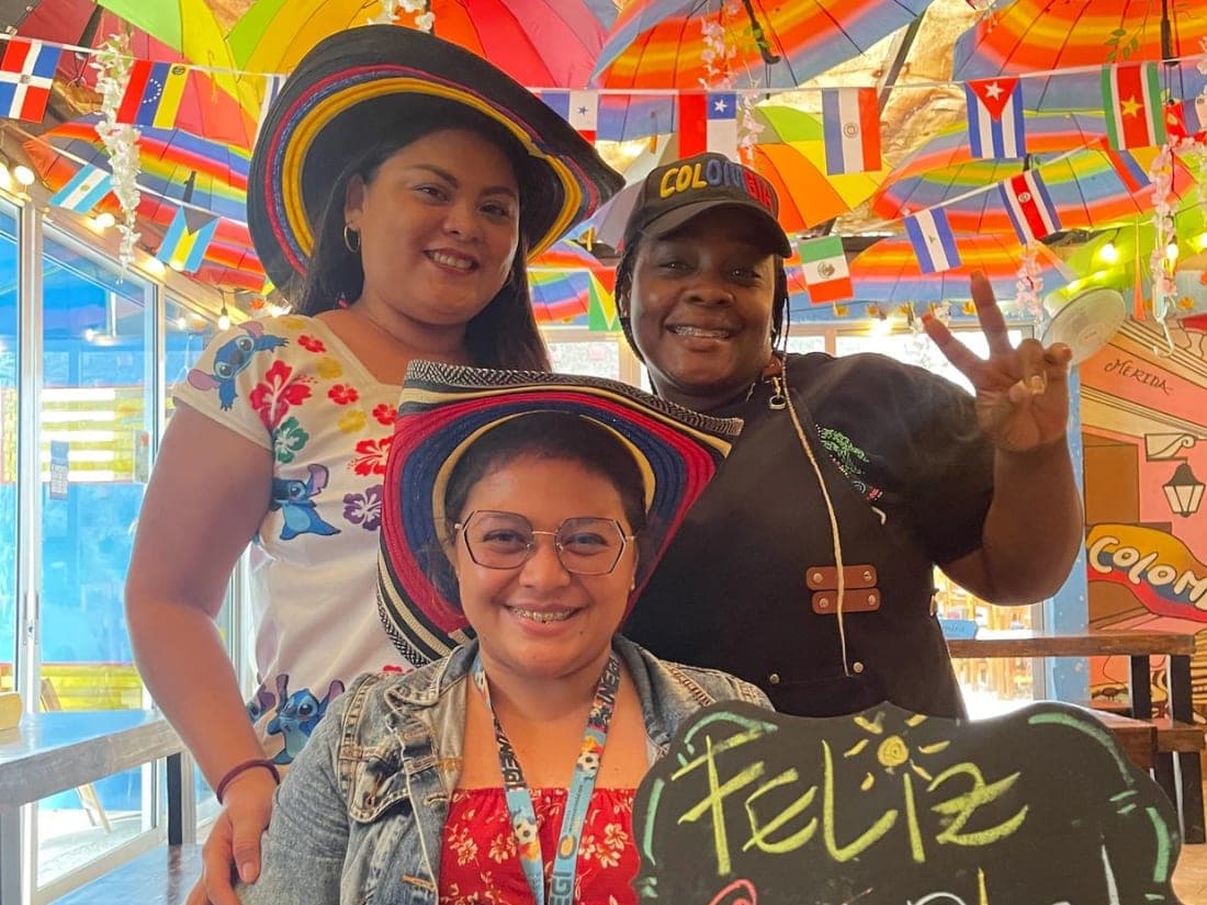 Grupo celebrando un cumpleaños en Parceros con sombreros vueltiaos y un pizarrón de Feliz Cumple